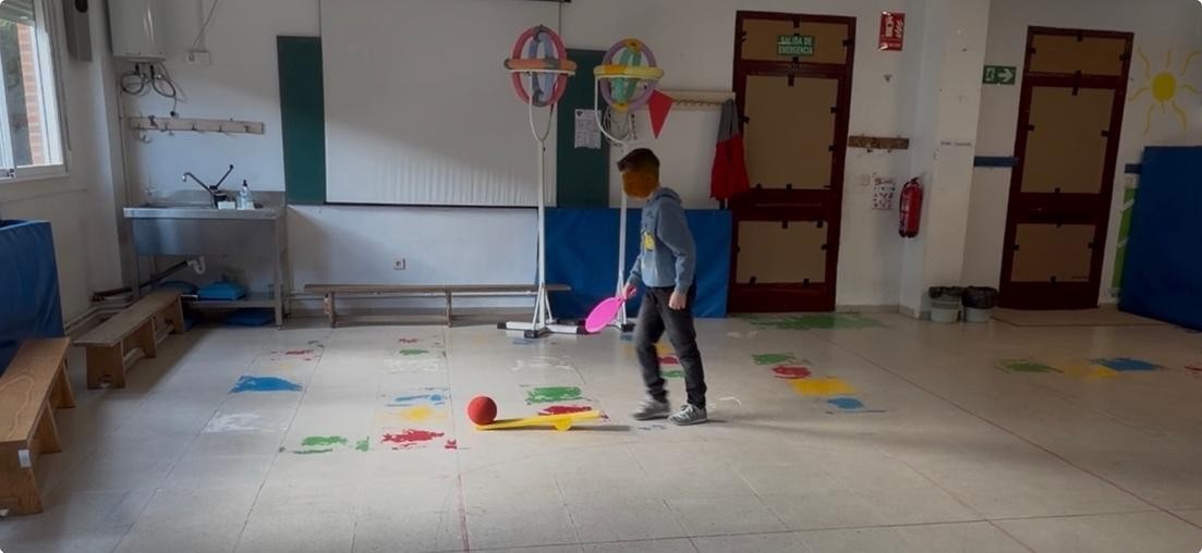 Niño practicando golpeos con raquetas usando lanzadores de pelotas
