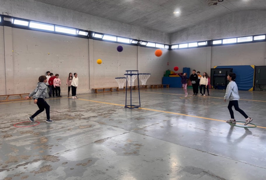 Niños jugando al minibasket con una canasta infantil