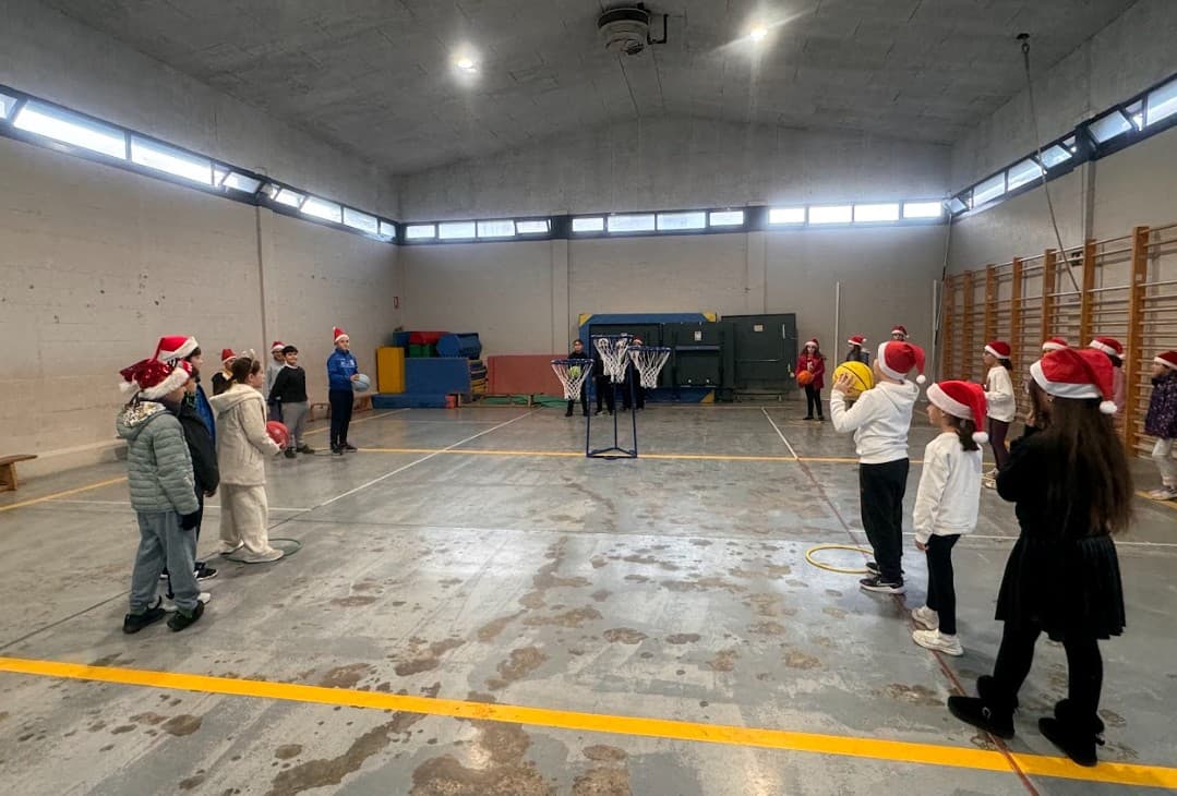 Niños realizando ejercicios con canasta de minibasket