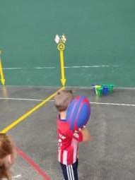  niño derribando conos con balón de rugby